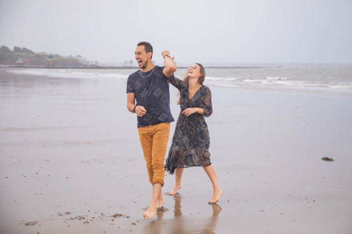 futurs mariés heureux sur la plage en séance d'engagement